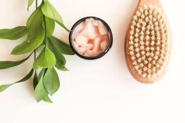 Beyaz arka planda yüz maskesi ve vücut fırçası. Bakımlı bir bayan için cephanelik.