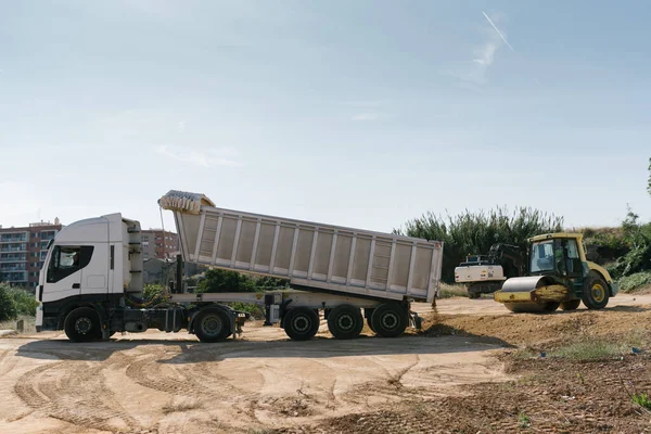 Toprak ve taşları taşıyan kamyon, açık araziye malzeme atıyor.
