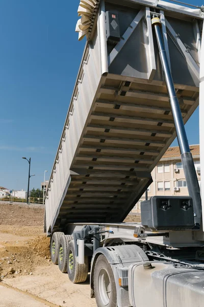 Toprak ve taşları taşıyan kamyon, açık araziye malzeme atıyor.
