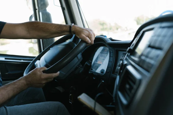 Adamın elleri büyük bir tonaj kamyonu kullanıyor.