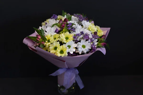 一束华丽明亮的鲜花 用黑色底色的装饰纸包在一起 淡紫色 金银花 图库图片