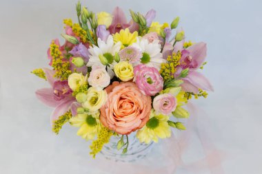 Açık arkaplanda muhteşem bir demet taze çiçek (Renkler: beyaz, pembe, sarı, yeşil. Çiçekler: gül, mutluluk, kasımpatı, orkide, aslanağzı.)