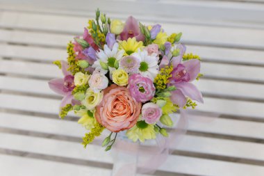 Açık arkaplanda muhteşem bir demet taze çiçek (Renkler: beyaz, pembe, sarı, yeşil. Çiçekler: gül, mutluluk, kasımpatı, orkide, aslanağzı.)