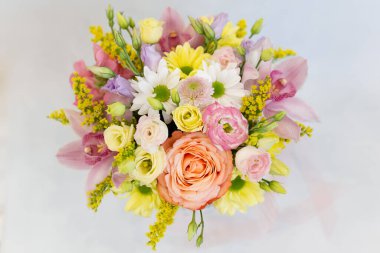 Açık arkaplanda muhteşem bir demet taze çiçek (Renkler: beyaz, pembe, sarı, yeşil. Çiçekler: gül, mutluluk, kasımpatı, orkide, aslanağzı.)