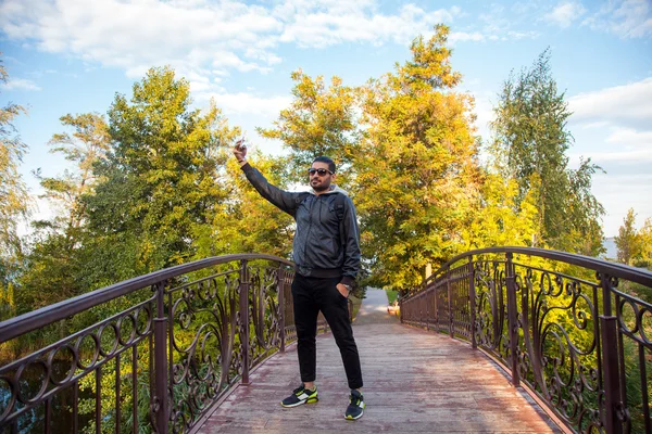 Doğada bir selfie alarak ve gülümseyen bir adam