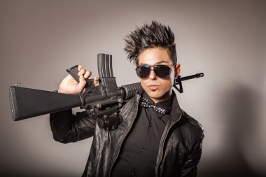 Elinde silah siyah elbiseli adam.