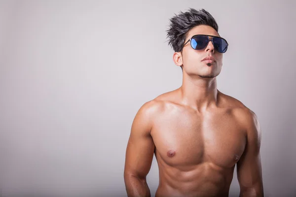 Handsome guy shirtless on a gray background — Stock Photo, Image