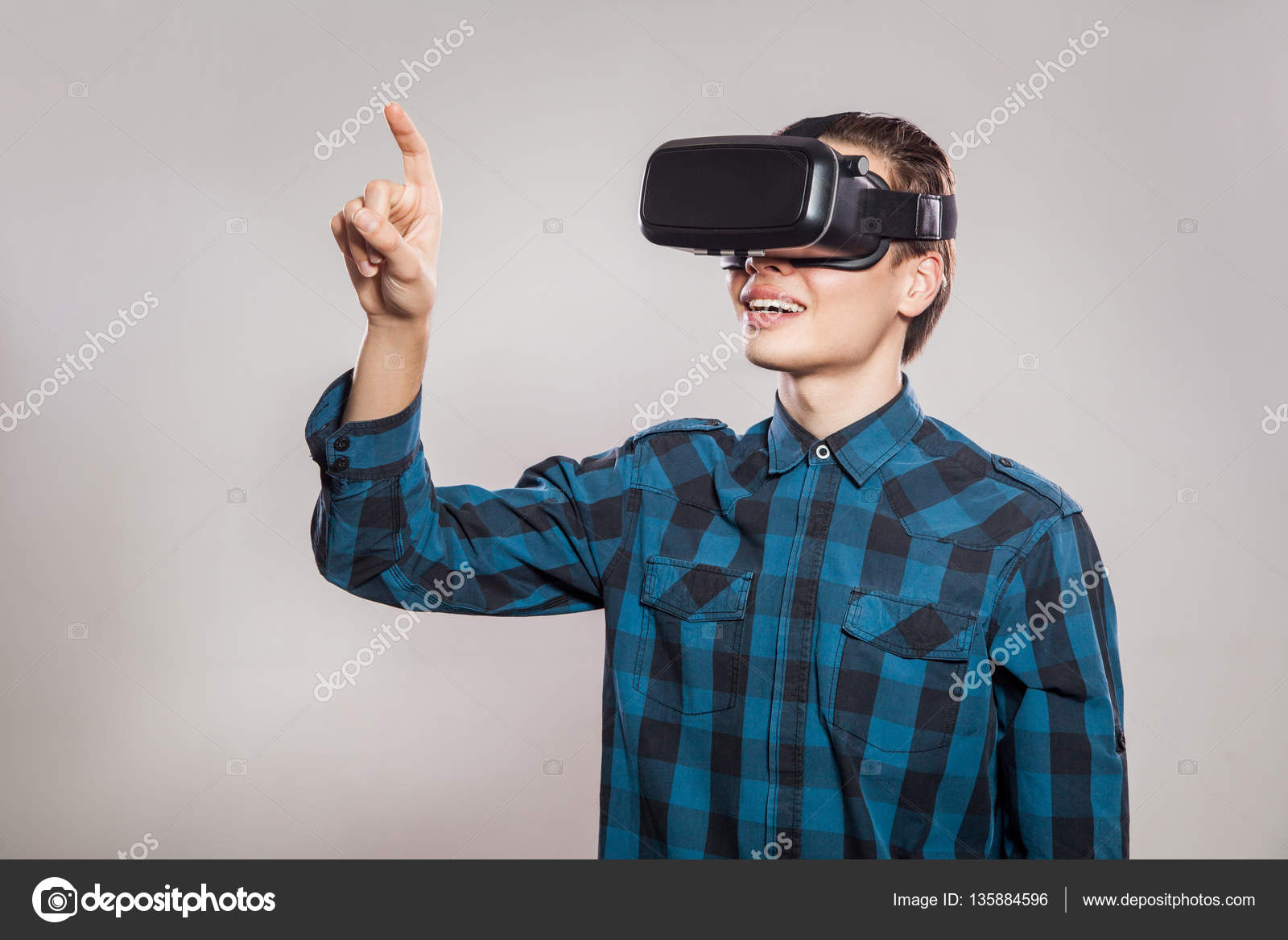 Emotional funny man wearing virtual reality goggles. Studio portrait of ...
