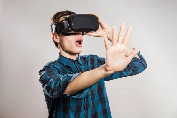 Emotionaalinen hauska mies yllään virtuaalitodellisuus suojalasit. Studio muotokuva videopeli suunnittelija yllään VR kuulokkeet. studio ampui eristetty harmaalla pohjalla . — kuvapankkivalokuva