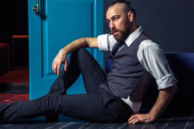 Kapı kırmızı ışık ile yakın takım elbiseli şık genç moda modeli. İş tarzı. Moda görüntü. Gece elbisesi. Seksi bir adam ayakta ve kameraya bakıyor. Moda bakmak.