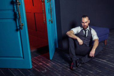 Kapı kırmızı ışık ile yakın takım elbiseli şık genç moda modeli. İş tarzı. Moda görüntü. Gece elbisesi. Seksi bir adam ayakta ve kameraya bakıyor. Moda bakmak.