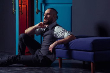 Kapı kırmızı ışık ile yakın takım elbiseli şık genç moda modeli. İş tarzı. Moda görüntü. Gece elbisesi. Seksi bir adam ayakta ve kameraya bakıyor. Moda bakmak.