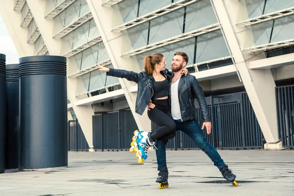 Hermosa pareja de patinadores con estilo hipster patinaje después de la lluvia . — Foto de Stock