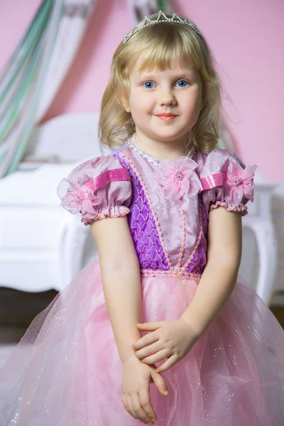 Pequena menina princesa feliz em vestido rosa e coroa em seu quarto real posando e sorrindo . — Fotografia de Stock