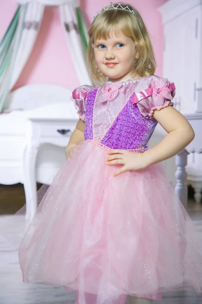 Pequena menina princesa feliz em vestido rosa e coroa em seu quarto real posando e sorrindo . — Fotografia de Stock