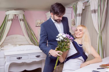 Güzel kız arkadaşı şaşırtıcı yakışıklı delikanlı ve onun buket mor beyaz çiçek verir.