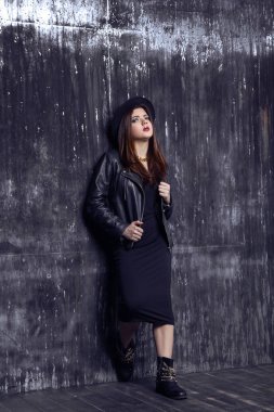 Moda güzel Orta Doğu hippi tarzı ile ayakta ve eski püskü duvara yakın poz modelidir.