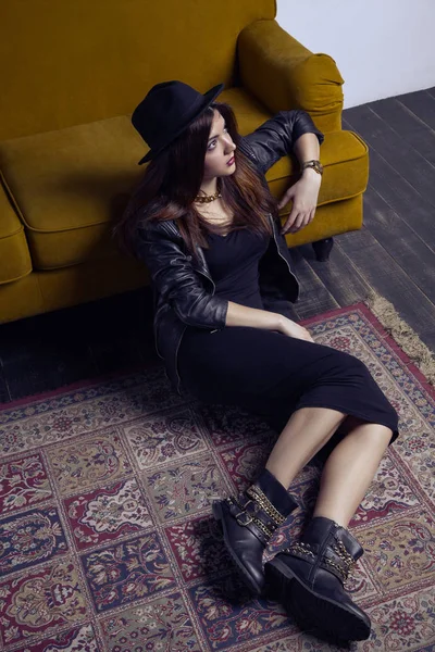 Mode schöne nahöstliche Modell mit Hipster-Stil posiert auf Teppich und gelbem Sofa. — Stockfoto