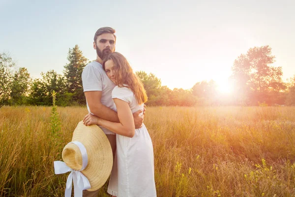 Happy beautiful couple hugs in park in the on the sunset. — Stock Photo, Image