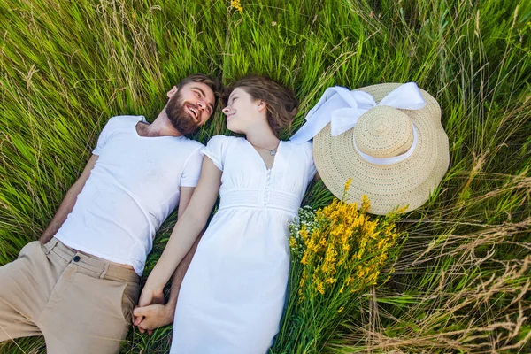 Feliz jovem relaxado casal no amor deitado na grama sobrecarga — Fotografia de Stock