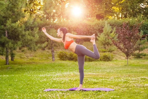 Giovane donna che pratica yoga nel parco. — Foto Stock