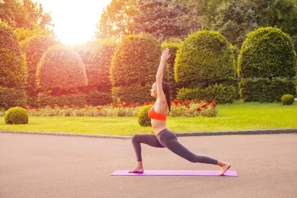 Jeune femme pratiquant le yoga dans le parc. — Photo