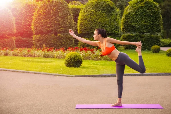 Jeune femme pratiquant le yoga dans le parc. — Photo