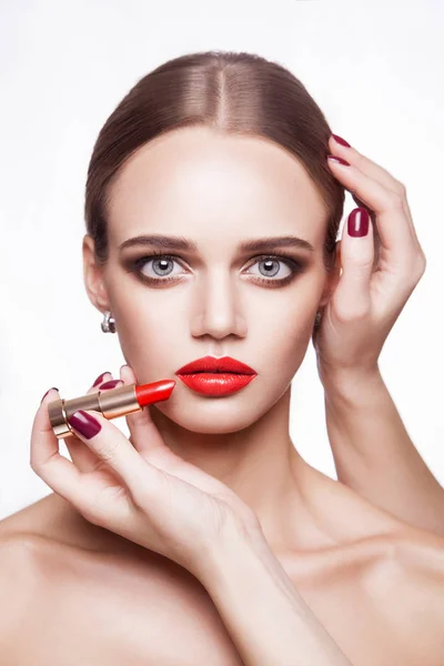 Artista de maquiagem profissional aplica maquiagem para bela jovem com olhos azuis e estilo de cabelo marrom claro e pele perfeita . — Fotografia de Stock