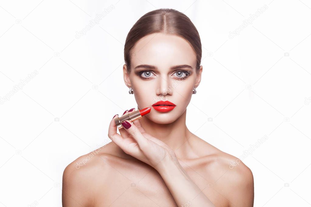 professional makeup artist applies makeup for beautiful young woman with blue eyes and light brown hair style and perfect skin. 