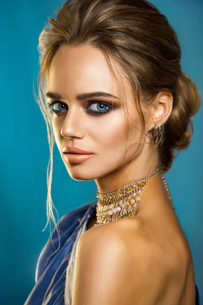 Hermosa mujer de moda con cabello castaño y maquillaje de noche con traje de fiesta azul púrpura. Joyería y Belleza . —  Fotos de Stock