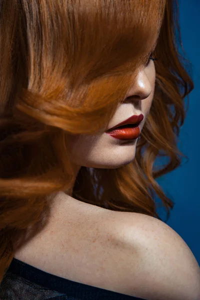 Krásné módní dívka s červenými dlouhé vlnité hnědé vlasy. světlovlasý model s kudrnatý účes a módní kouřové líčení . — Stock fotografie