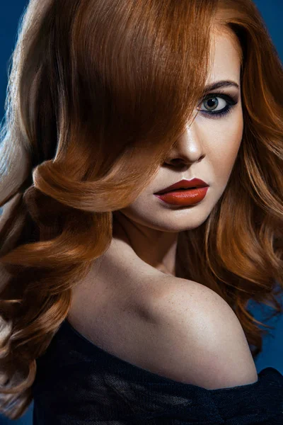 Krásné módní dívka s červenými dlouhé vlnité hnědé vlasy. světlovlasý model s kudrnatý účes a módní kouřové líčení . — Stock fotografie