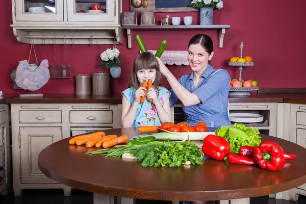 Lycklig mor och dotter njuta av att göra och ha hälsosam måltid tillsammans på deras kök. de är att göra grönsakssallad och att ha roligt tillsammans. mamma ta hand om sin dotter och tech hur cook. — Stockfoto