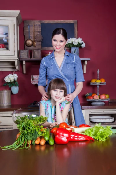 Mãe e filha felizes gostam de fazer e ter uma refeição saudável juntos em sua cozinha. eles estão fazendo salada de legumes e se divertindo juntos. mãe cuidar de sua filha e tecnologia como cozinhar . — Fotografia de Stock