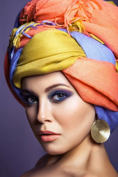 Mulher bonita com headwear colorido e maquiagem azul . — Fotografia de Stock