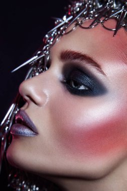 moda güzellik model metalik şapkalar ve parlak gümüş kırmızı makyaj ve mavi gözleri ve siyah arka plan üzerinde kırmızı kaşları ile