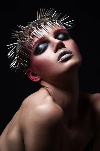 Fashion Beauty Model mit metallischer Kopfbedeckung und glänzendem silberrotem Make-up und blauen Augen und roten Augenbrauen auf schwarzem Hintergrund — Stockfoto