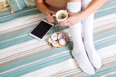 Yumuşak yatakta tablet ve kahve ile kadın fotoğrafı.