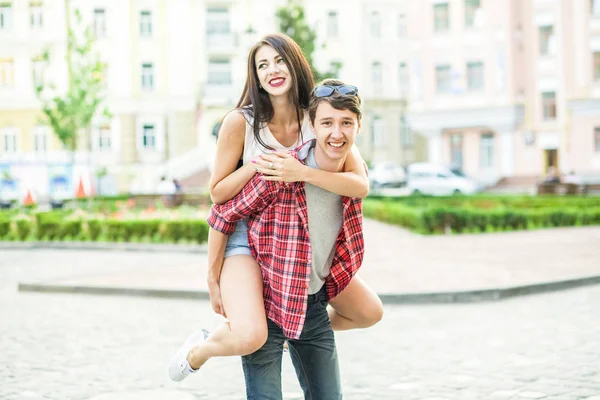 Feliz pareja sonriente divirtiéndose en la calle en verano . — Foto de Stock