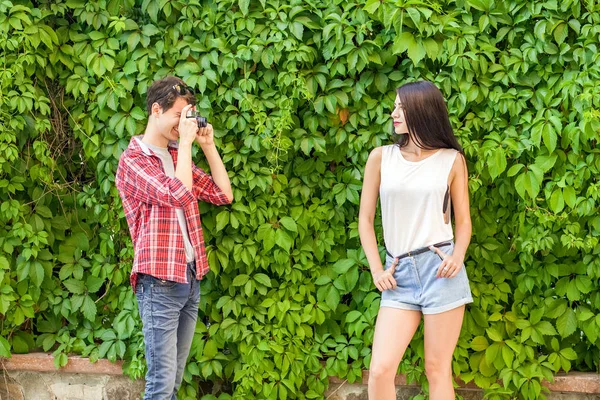 Fotograf schießt schöne Brünette Modell in der Nähe der grünen Mauer. — Stockfoto