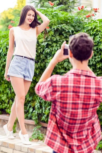 Fotograaf schieten van mooie brunette model in de buurt van de groene muur. — Stockfoto