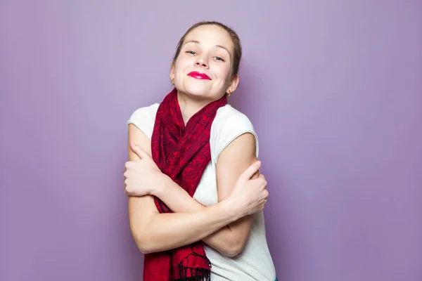 Retrato de una joven linda mujer con bufanda roja y pecas en su cara sonriente felicidad despreocupada concepto de expresión emocional sobre fondo púrpura — Foto de Stock