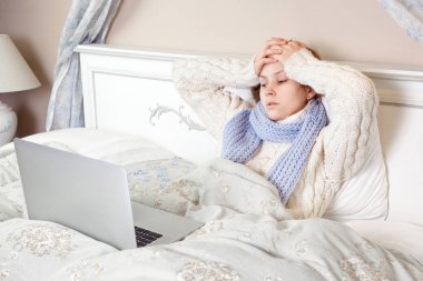 Hasta bir kadın duygu kötü, dinlenme ve onu dizüstü bilgisayar ve internet ile onun yatağında evde çalışma. 