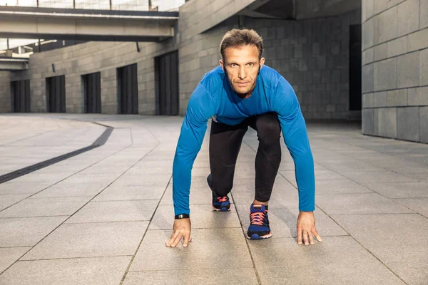 Knappe middelste leeftijd ernstige man in blauw zwart sport uniform uitgevoerd. — Stockfoto