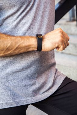 Şişe su ile sporcu istirahat ve akıllı saatini çalıştırdıktan sonra kontrol. Fitness, spor, egzersiz ve insanlar sağlıklı yaşam konsepti.