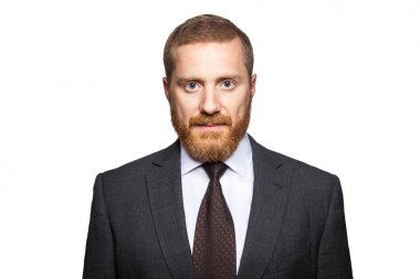 Sakallı işadamı kameraya bakıyor. 