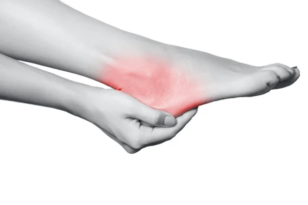 Nahaufnahme einer jungen Frau mit Schmerzen am Bein. isoliert auf weißem Hintergrund. Schwarz-Weiß-Foto mit rotem Punkt. — Stockfoto
