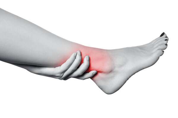 Closeup view of a young woman with pain on leg. isolated on white background. Black and white photo with red dot.