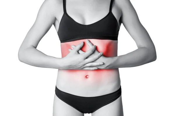 Vista de cerca de una mujer joven con dolor de estómago o digestión o ciclo menstrual. aislado sobre fondo blanco. Foto en blanco y negro con punto rojo . —  Fotos de Stock