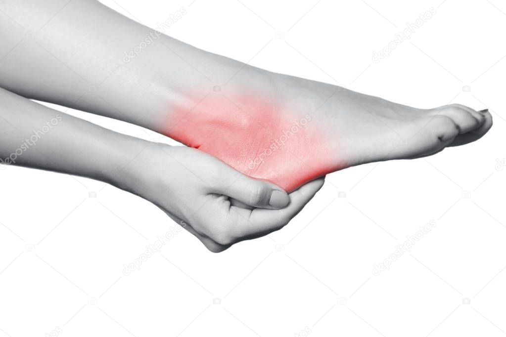 Closeup view of a young woman with pain on leg. isolated on white background. Black and white photo with red dot.